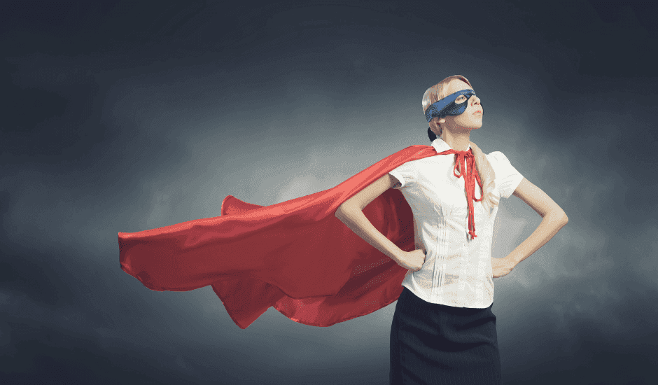 A teacher wearing a superhero costume, standing with her hands on her hips, showing that teaching is a superpower.