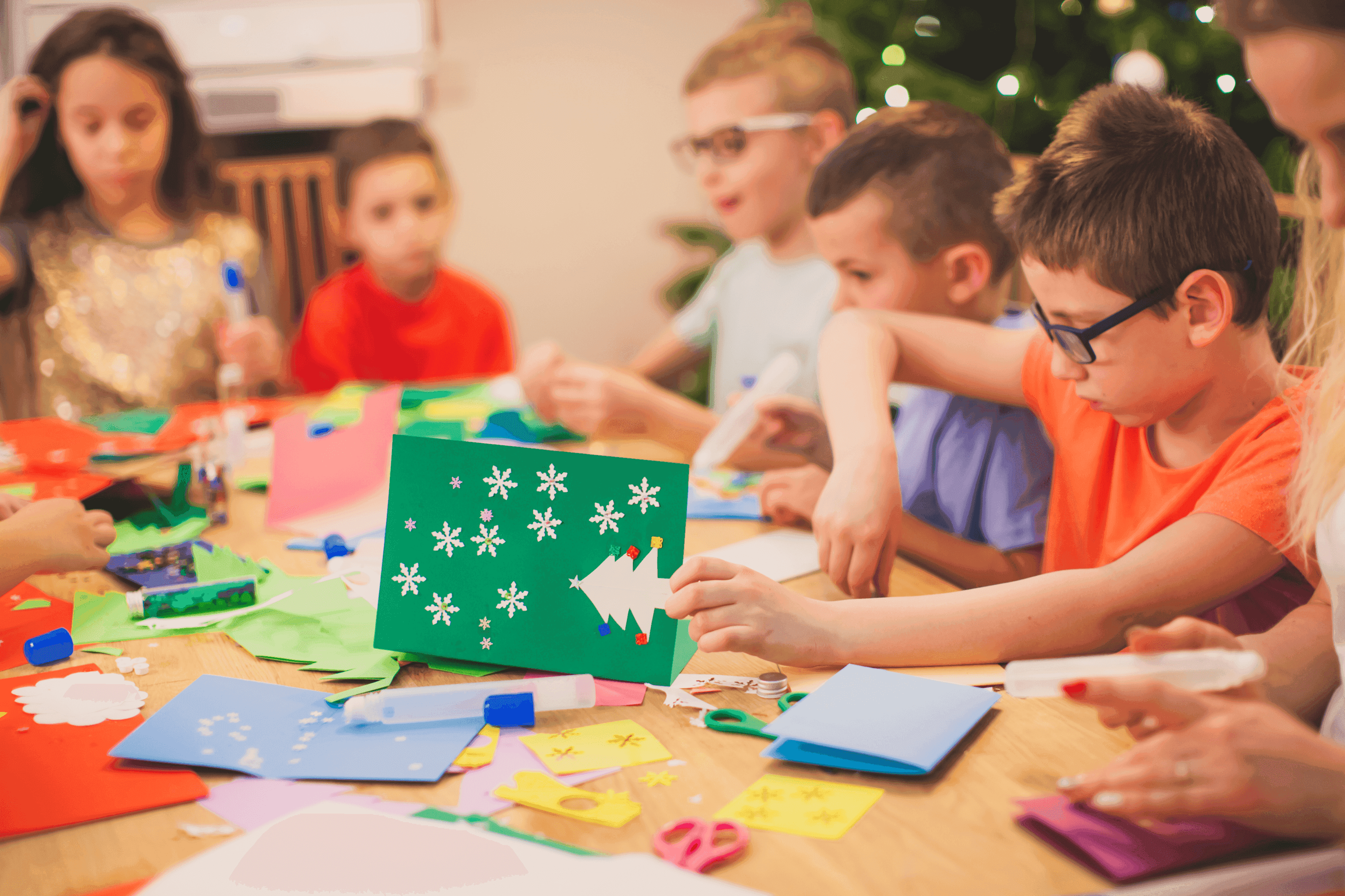 Children making Christmas cards at a table